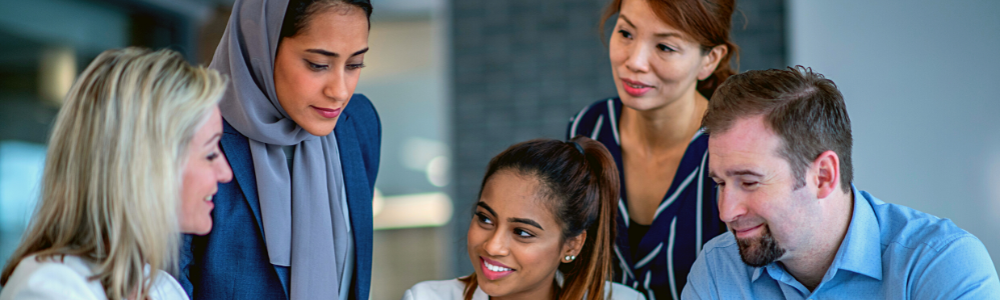 group of diverse employees looking at something together