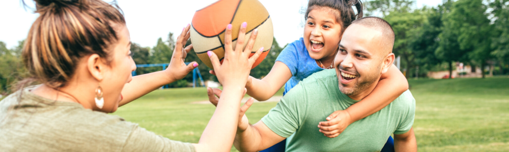 young latinx family playing ball outdoors