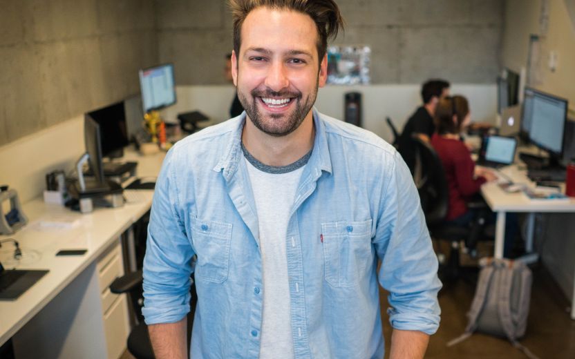 young man standing in front of computers